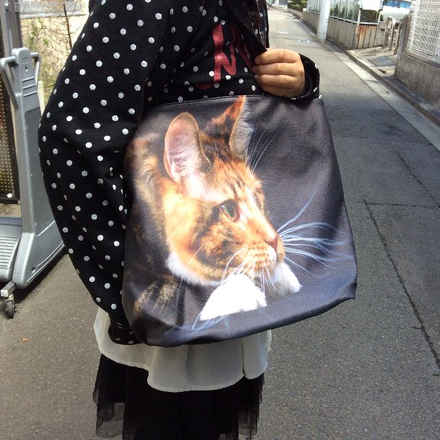 茶トラ猫フォトデカトートバッグを人間との大きさの比較のため肩に掛けた状態の画像