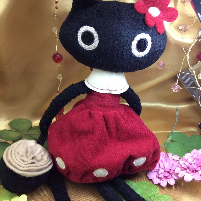 マタノアツコ先生お花のバッグを提げて赤いワンピースを着飾る黒猫メメちゃん縫いぐるみの全体写真