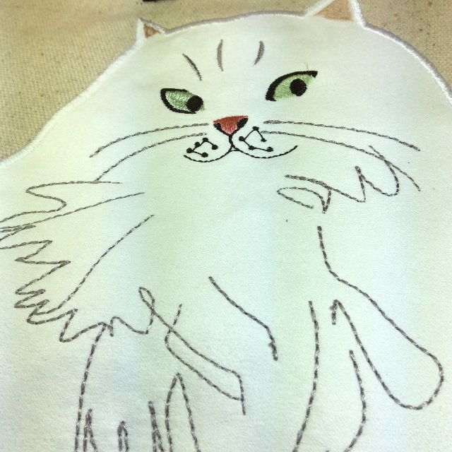 ルートートの白猫フリルがま口バッグの白猫アップリケ部分を大きく写した画像