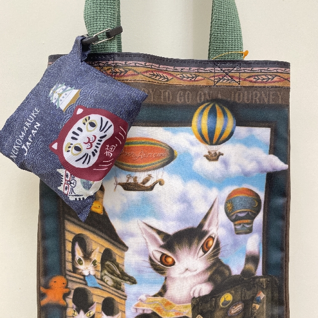 クスグルジャパンコンビニエコバッグ猫だるま＆ネコザワ柄を畳んでバッグの持ち手に付けた画像
