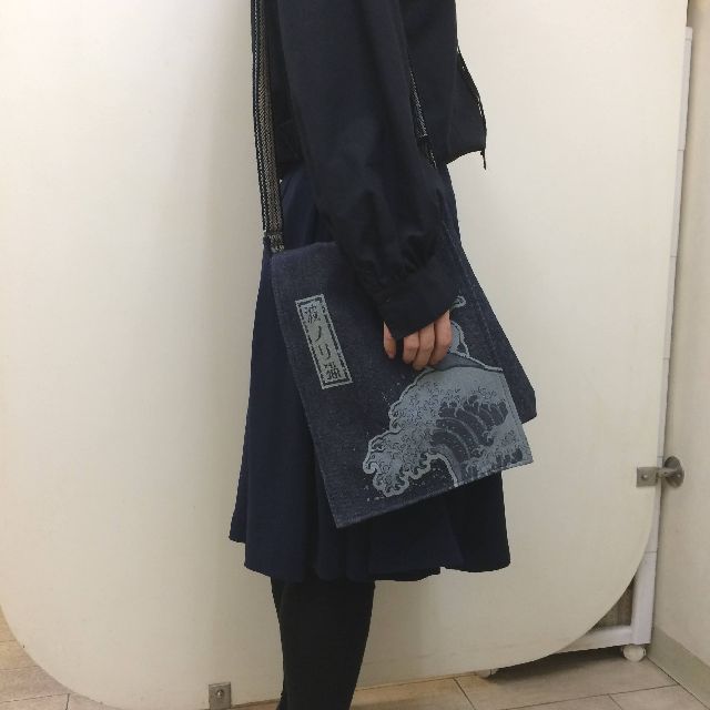 倉敷デニムのショルダーバッグ「波ノリ猫」柄を肩に掛けた画像