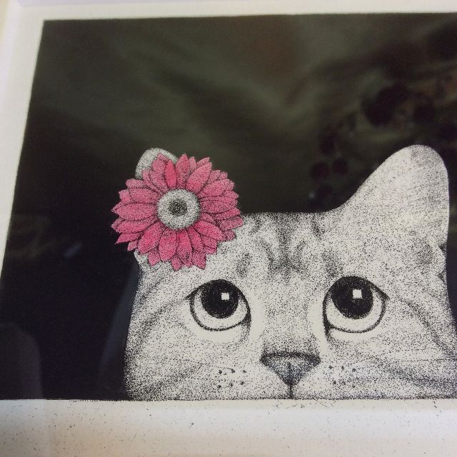 東マユミさんの銅版画「なにみてるの」のピンクの花を頭に付けた猫の画像