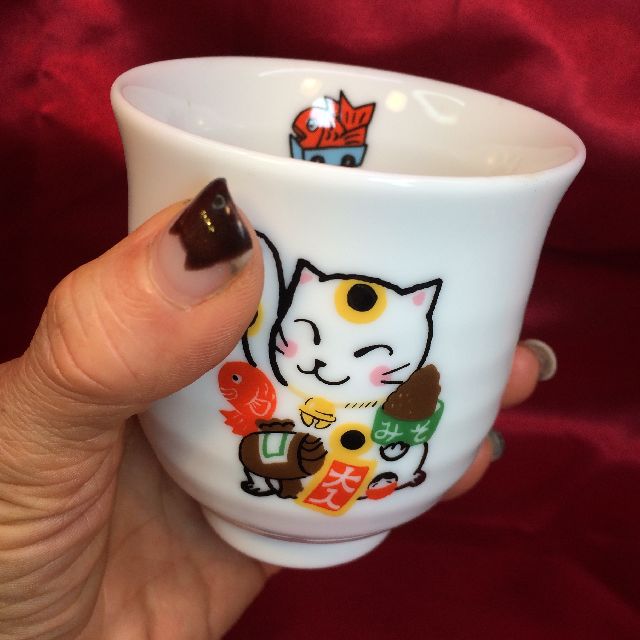ゼルポティエかとうしんじ招き猫湯飲み茶わんを手で持った画像