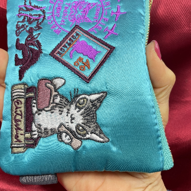 猫のダヤンの刺繍サテンポーチ「旅するBABY」柄を手に持った画像