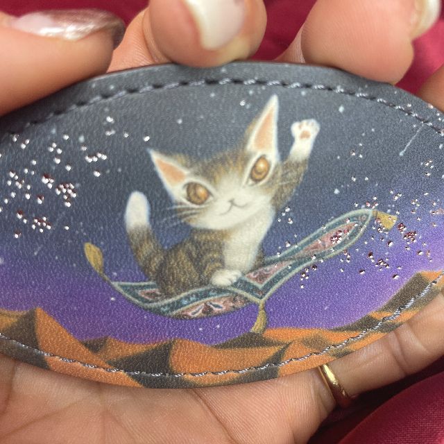 猫のダヤンのオーバルバレッタ空飛ぶ絨毯柄を手に持った画像