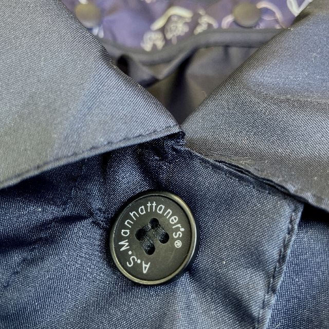 マンハッタナーズのレインコート「ミュージックキャット」柄ネイビー色のロゴ入りボタンの画像