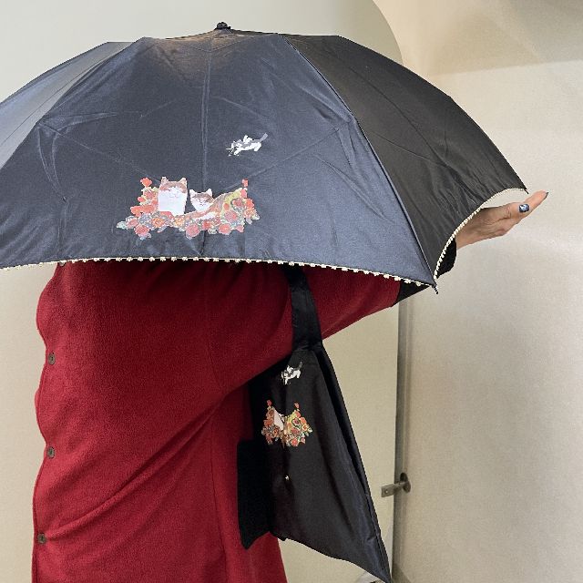 猫のマンハッタナーズの折りたたみ傘「天使の祝福」柄を差して手を伸ばした画像