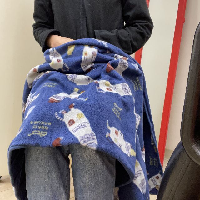 クスグルジャパンのひざ掛けネコザワ柄ネイビー色を膝に掛けた画像