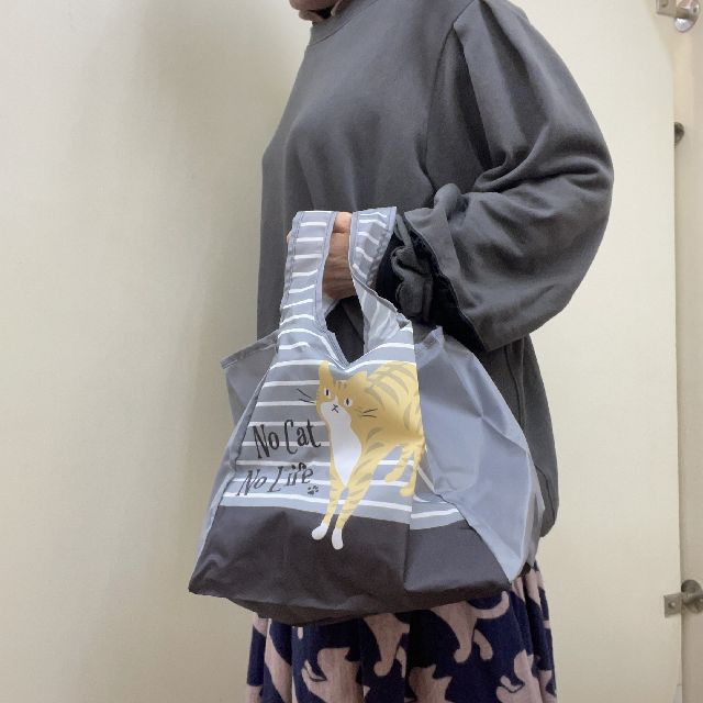 大西賢のコンビニエコバッグチャトラ猫柄グレー色を手に持った画像