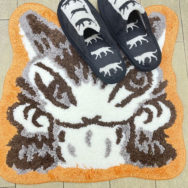 猫のダヤンのダイカットラグほおづえ柄の上にスリッパを置いた画像