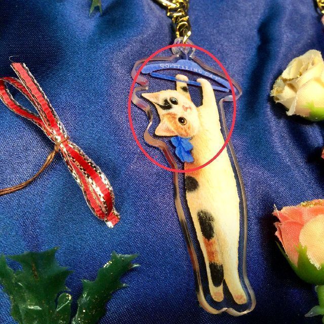 ポタリングキャットアクリルキーホルダー三毛猫の青いハンガーとリボン部分のクローズアップ画像