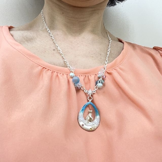 パルナートポックの猫ネックレス浜辺柄を首に掛けた画像