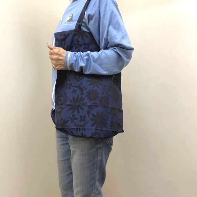 マタノアツコのトートバッグ猫のいる庭柄を肩に掛けた画像